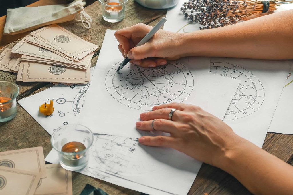 Numerologist calculating a personal year forecast chart by hand with traditional tools